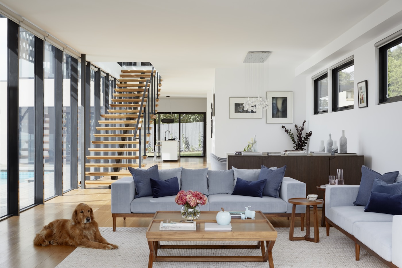 Open living room with timber stair and glass walls